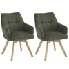 Two green dining chairs with wooden legs against a white background. Podgląd zdjęcia produktu