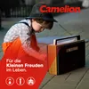 A young boy in a hat and suspenders is playing with a vintage radio outdoors. Podgląd zdjęcia produktu