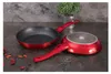Two red frying pans are displayed on a dark gray countertop, with a small potted plant in the background. Podgląd zdjęcia produktu