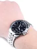 A close-up shot of a man's wrist wearing a silver Citizen Eco-Drive watch with a black face. Podgląd zdjęcia produktu