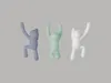 Three stylized figures in different colors are arranged in a line against a plain gray background. Náhled obrázku produktu
