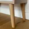Close-up of the wooden legs of a piece of furniture, likely a wardrobe, on a wooden floor. Produktbild-Vorschau