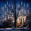 A tree decorated with icicle-shaped lights in a snowy setting at night, with a house in the background. Náhled obrázku produktu