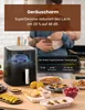 A person holding a baby in a kitchen with an air fryer and food on a table. Produktbild-Vorschau