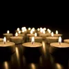 A close-up shot of multiple lit tea light candles on a dark surface. Náhled obrázku produktu