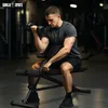 A man is performing bicep curls with a dumbbell while sitting on a black adjustable weight bench in a gym. Produktbild-Vorschau