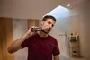 A man is shaving his face in a modern bathroom. Podgląd zdjęcia produktu