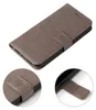 A gray flip case for a smartphone, with floral embossed patterns, shown from a slightly elevated angle. Two close-up insets show the strap closure and the inside of the case. Produktbild-Vorschau
