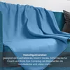 A blue fleece blanket draped over a sofa. Náhľad obrázku produktu