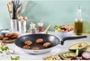 A kitchen scene with a frying pan cooking falafel, surrounded by ingredients and kitchen utensils. Voir les images du produit