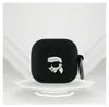 A black AirPods case with a Karl Lagerfeld cartoon character design is displayed on a white platform with a light gray background. Anteprima dell’immagine prodotto
