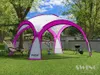 A pink and white event pavilion set up in a grassy backyard with trees and a fence in the background. A lounge chair and a grill are also visible. Produktbild-Vorschau