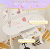 A white children's vanity table with various toy makeup and accessories, featuring a lighted mirror and an open drawer. Produktbild-Vorschau