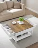 A square coffee table with a wooden top and white base is shown in a living room setting. Náhled obrázku produktu