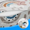 Close-up of a folded mattress with a zipper, showing a colorful pattern and text overlays describing its features, alongside an inset image of a washing machine. Produktbild-Vorschau