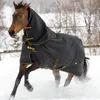 A brown horse wearing a black and gold Bucas turnout rug runs through the snow. Voir les images du produit