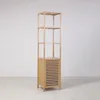 A tall, narrow bamboo shelving unit with a cabinet at the bottom, displayed in a minimalist setting. Voir les images du produit