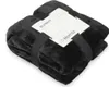 A folded black blanket with a product tag attached. Produktbild-Vorschau