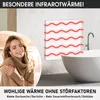 A woman is embracing herself in a cozy setting, with an infrared heater emitting heat waves in the background, next to a bathtub. Produktbild-Vorschau