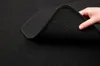 A hand is lifting a corner of a black car mat. Produktbild-Vorschau