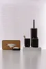 A set of black bathroom accessories with wood accents, including a tissue box, soap dish, toothbrush holder, and toilet brush holder, arranged on a white surface against a white background with horizontal blinds. Náhled obrázku produktu
