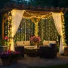 An outdoor patio area decorated with string lights and furniture. Produktbild-Vorschau