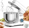 A white stand mixer with a stainless steel bowl and attachments is shown on a white surface, with baked goods and a salad in the background. Produktbild-Vorschau