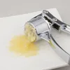 A close-up shot of a garlic press with crushed garlic on a white plate. Náhled obrázku produktu