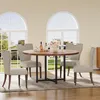 A round dining table with four chairs in a well-lit room with large arched windows. Produktbild-Vorschau