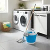 A laundry room scene with a washing machine, dryer, sink, and cleaning supplies. Voir les images du produit