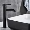 A black faucet is shown above a black and white sink in a bathroom setting. Anteprima dell’immagine prodotto