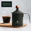 A manual milk frother and a glass of coffee are placed on a wooden board. Produktbild-Vorschau