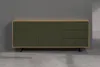 A dark green and oak sideboard is displayed against a gray wall and concrete floor. Podgląd zdjęcia produktu