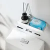 A white shelf with a black diffuser bottle and a package of wet wipes, mounted above a toilet tank. Anteprima dell’immagine prodotto