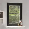 A window with a view of a lake and trees, with decorative items on the windowsill. Voir les images du produit