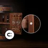 A wooden barrel-shaped bar cabinet with shelves and glass holders, featuring a close-up inset of a magnetic closure. Produktbild-Vorschau