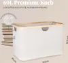 A beige storage basket with a wooden rim is shown with dimensions indicated. A stack of books is visible in the background. Náhľad obrázku produktu