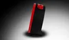 A side view of a black and red alarm clock with buttons on top, set against a gradient background. Produktbild-Vorschau