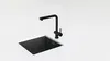 A black kitchen sink and faucet on a white countertop. Podgląd zdjęcia produktu