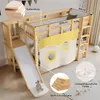 A children's loft bed with a slide and a yellow curtain, set up in a room. Produktbild-Vorschau