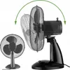 Two black desk fans are shown. One is in the foreground, viewed from the front and slightly to the side. The second fan is in the background, shown in profile and is translucent to indicate movement or different positions. A green curved arrow above the ba Anteprima dell’immagine prodotto