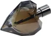 Herzförmiger Flakon des Parfums Diesel Loverdose Tattoo neben rosafarbener Verpackung mit floralem Muster und schwarzer Schrift. Produktbild-Vorschau