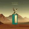 A perfume bottle with a golden eagle topper stands in a desert landscape with mountains in the background. Podgląd zdjęcia produktu