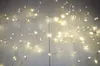 A string of warm white LED lights is spread across a light-colored wooden floor. Produktbild-Vorschau