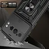 A close-up shot of a black phone case with a ring stand and camera cover, shown in a dynamic pose as if falling and cracking the surface it's hitting. Produktbild-Vorschau