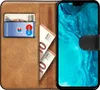 A book-style phone case with a phone inserted, showing cards and banknotes in the interior slots. Náhľad obrázku produktu