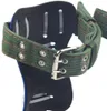 A close-up view of a climbing spur with a green strap and buckle. Náhled obrázku produktu