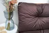 A close-up of a brown cushion on a pallet, with a vase of dried flowers and a small white table in the foreground. Anteprima dell’immagine prodotto