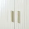Close-up of two white cabinet doors with vertical grooves and two white handles. Produktbild-Vorschau