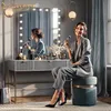 A woman applying makeup in front of a vanity mirror with LED lights. Voir les images du produit